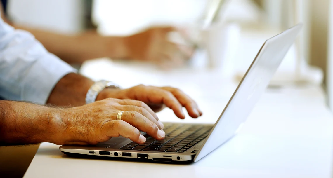 Händer som skriver på laptop.