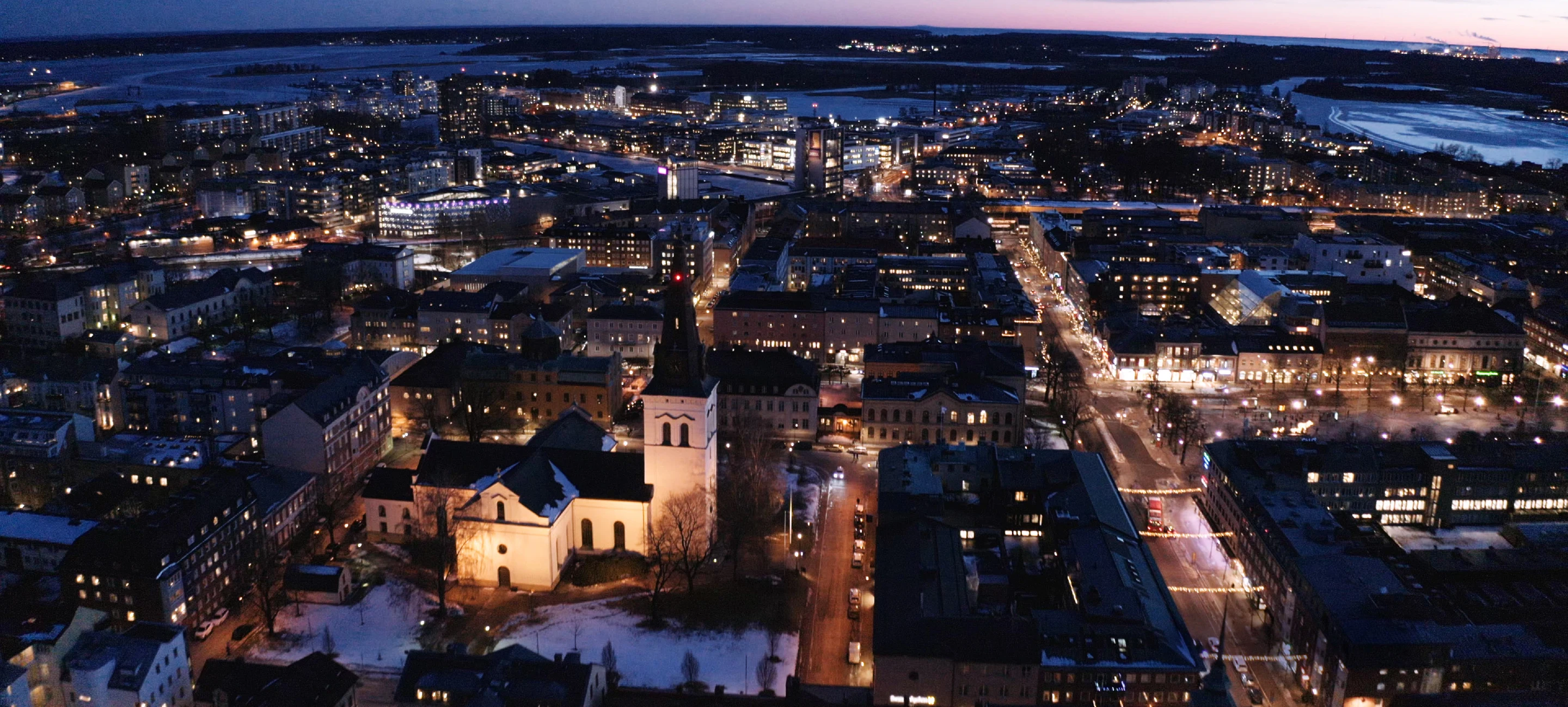 Flygfoto över centrala Karlstad med Domkyrkan i vintermörker