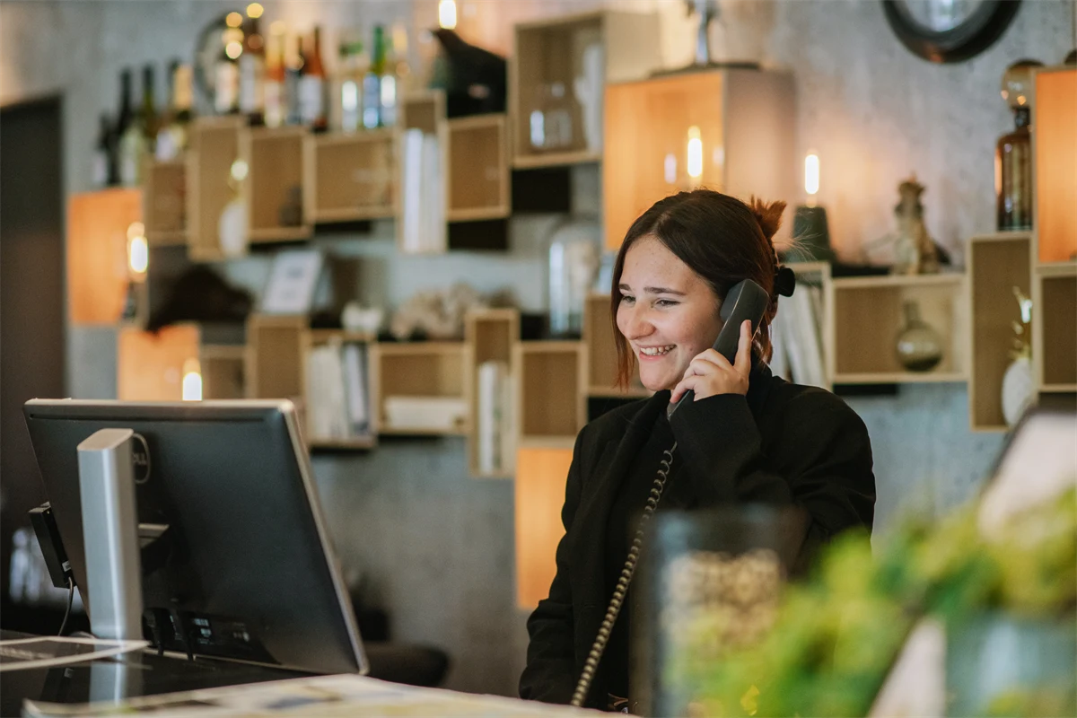 En gymnasieelev svarar i telefon i en reception där eleven har praktik.