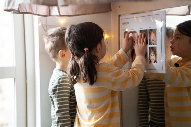 Pojke och flicka som tittar på bilder på en vägg