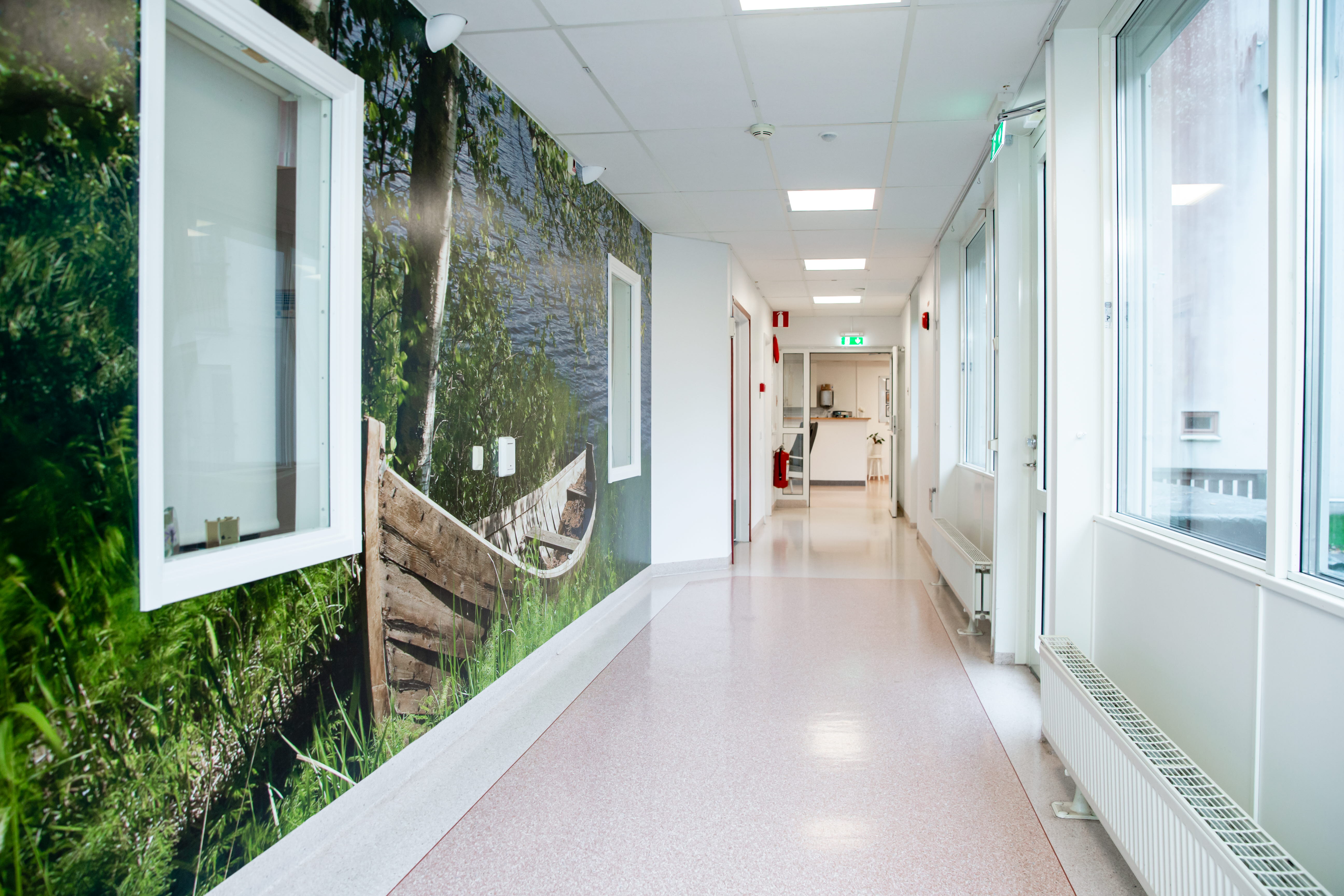 Lång korridor med fototapet med varma och gröna inslag