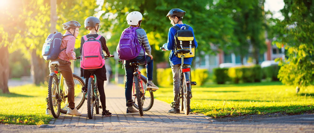 Fyra barn på cykel på cykelväg