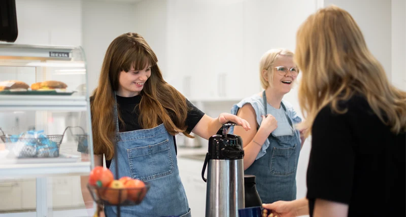 Elever som skrattar och jobbar i ett bageri