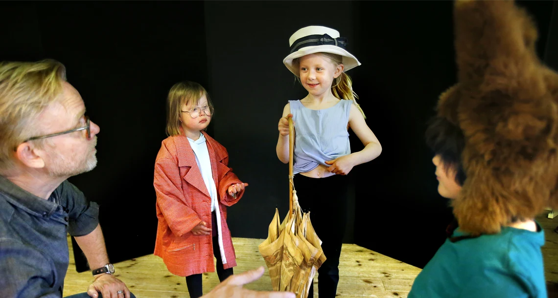 Grupp av elever och en lärare som spelar teater