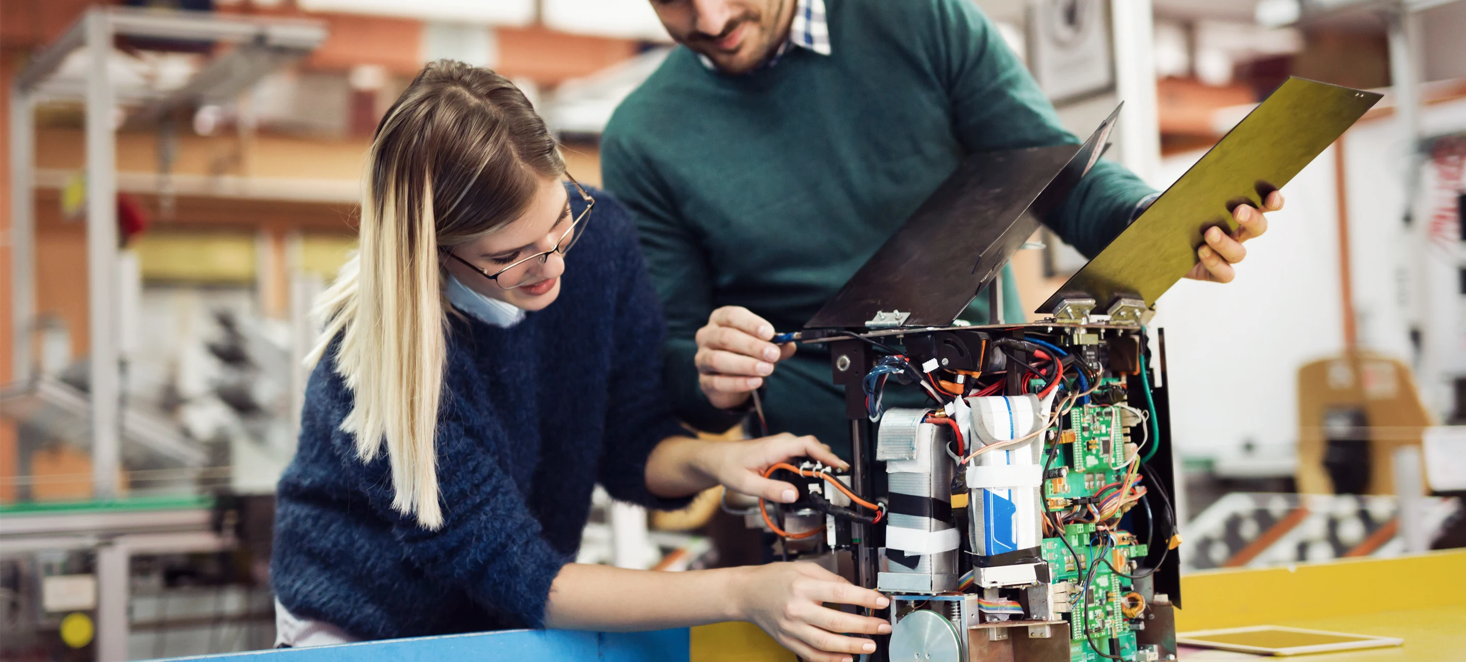 Två personer i ett klassrum skrattar.