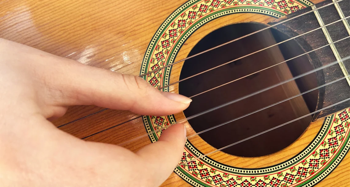 En hand som spelar gitarr
