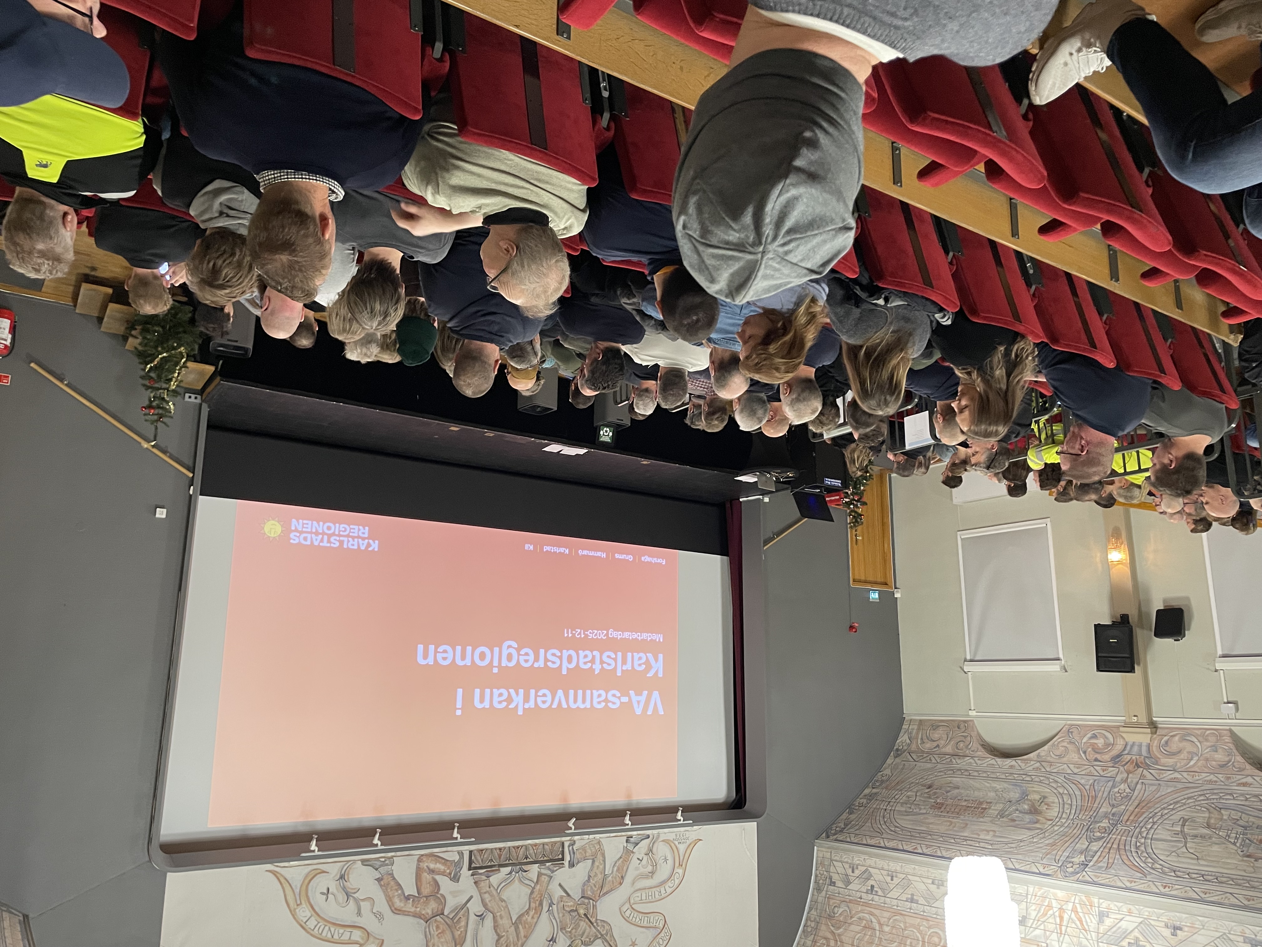 Personer sitter i stor salong