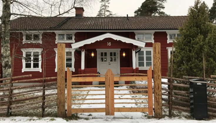 Ett rött trähus med vita knutar