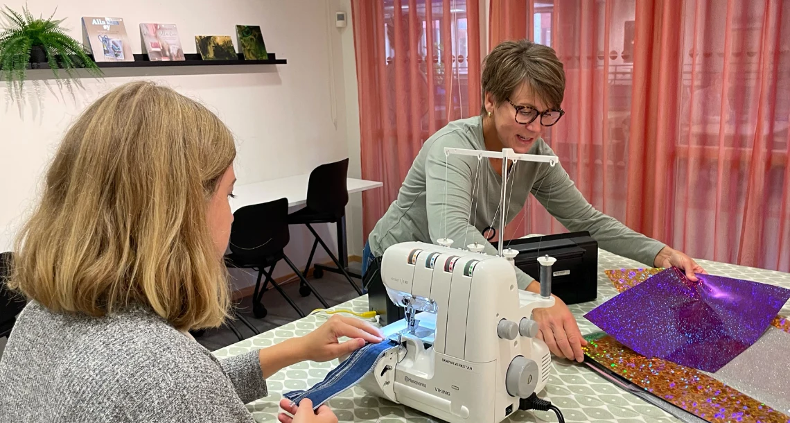 En person syr och den andra håller i vinyl