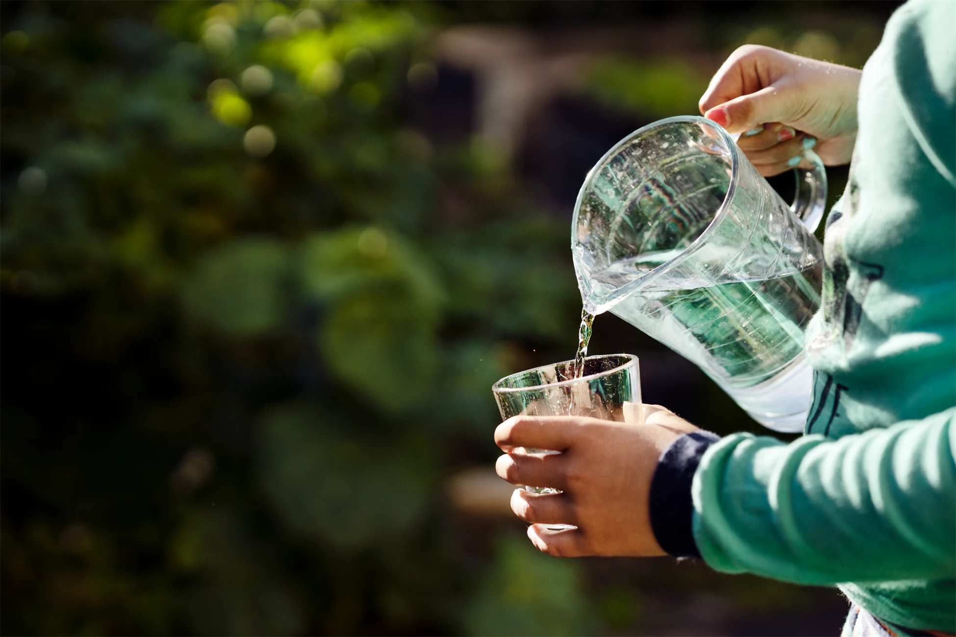 Person häller upp vatten i glas