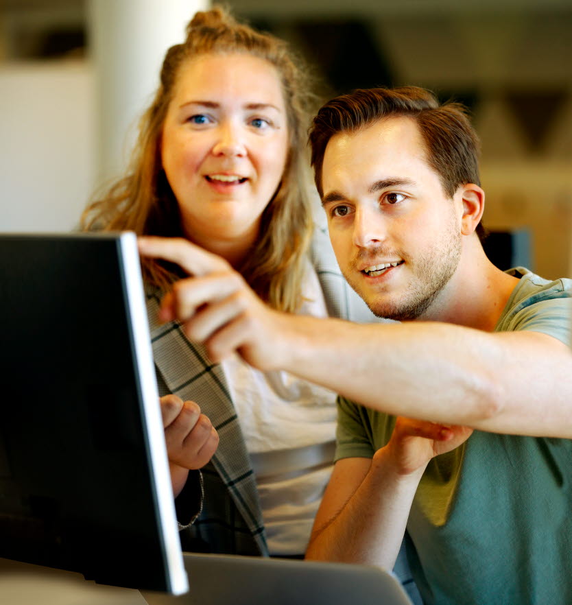 En kvinna och en man tittar på en dator tillsammans