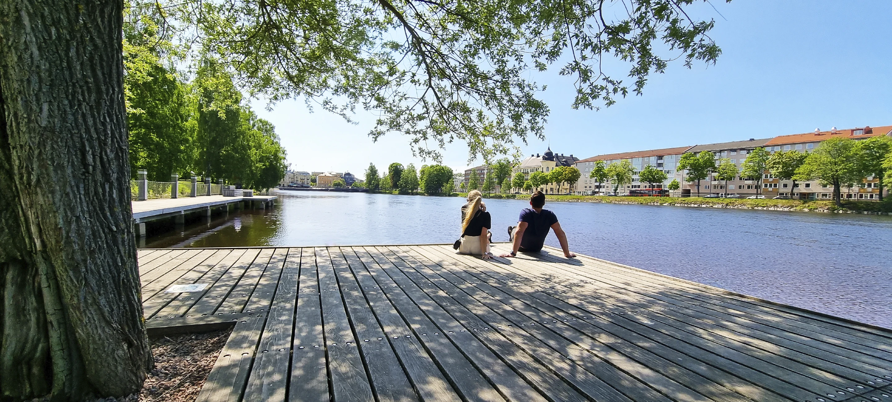 Två personer som sitter på en brygga vid Sandgrundsudden