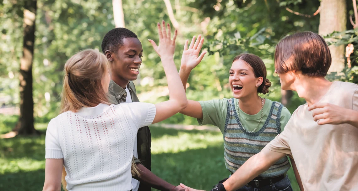 Fyra ungdomar som gör en high five