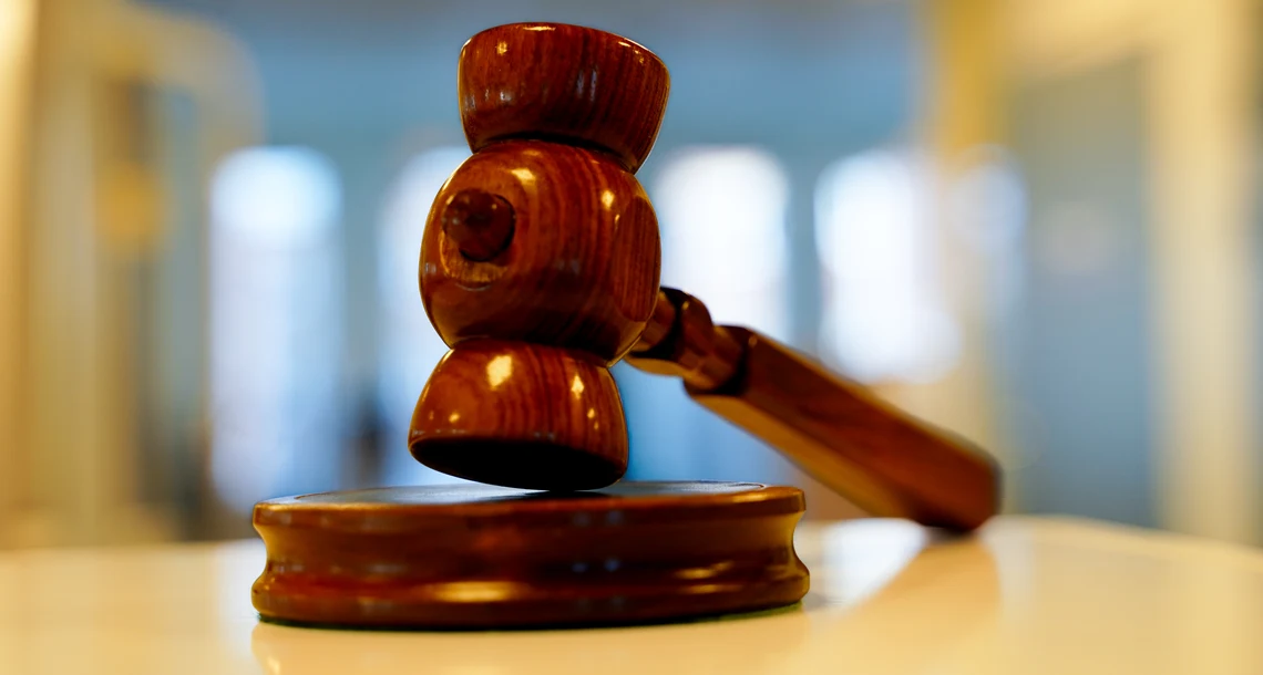 En ordförandeklubba i trä ligger på ett bord.