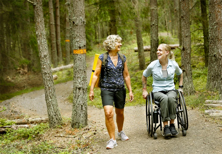 Två kvinnor på vandring på Jäverön. Den ena kvinnan sitter i rullstol.