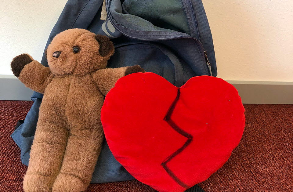 Bilden visar en nalle och ett hjärta lutat mot en ryggsäck