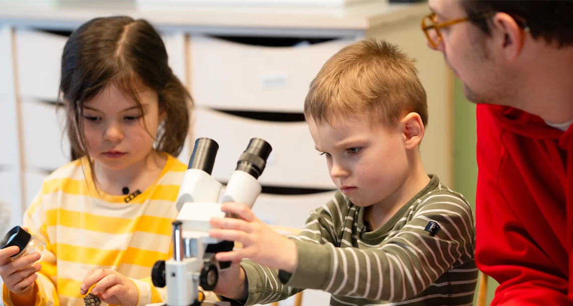Barn som interagerar med läromedel i förskolan tillsammans med pedagoger.