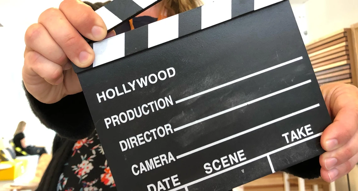 En person håller upp en filmklappa