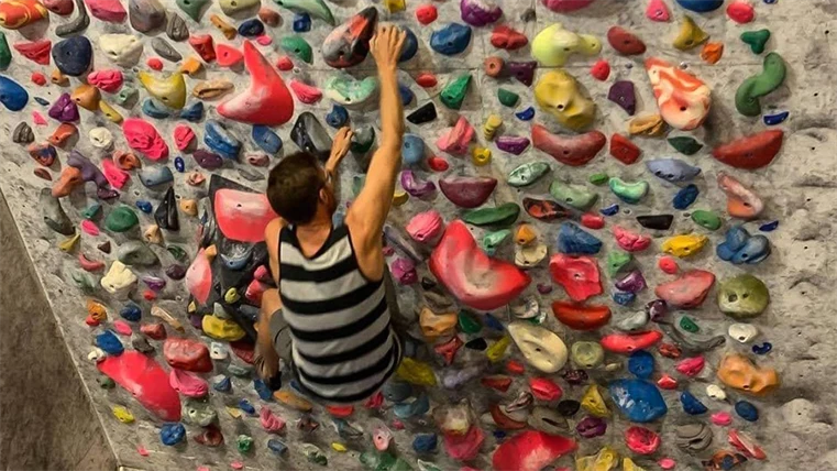 En person tar sig upp för en klättervägg