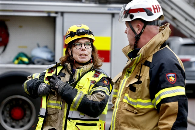 Två deltidsbrandmän som pratar med varandra.