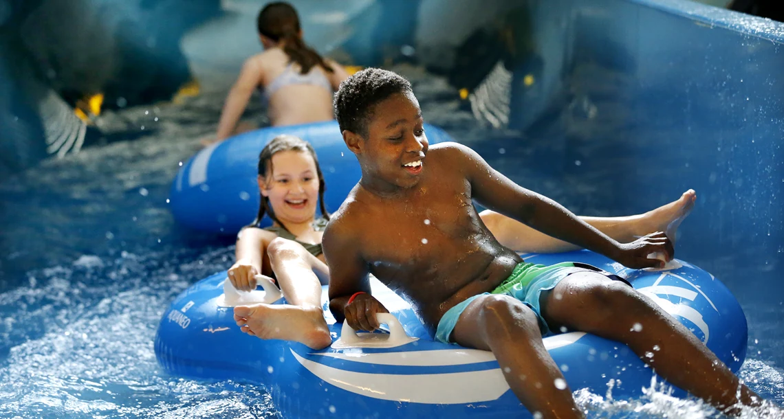 Barn som åker rutschbana tillsammans i en åkring