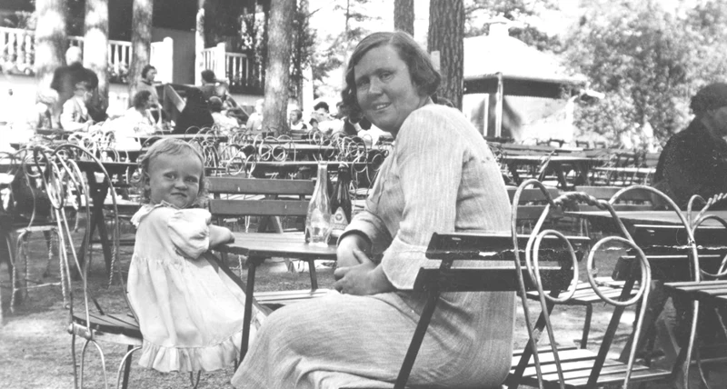 Mor och dotter fikar utomhus. 