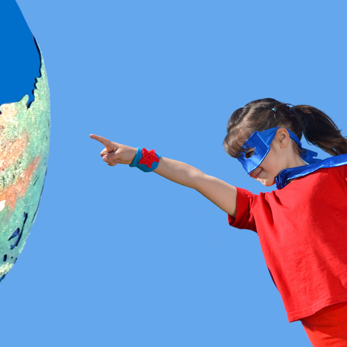 Ung person med superhjältedräkt pekat mot en jordglob