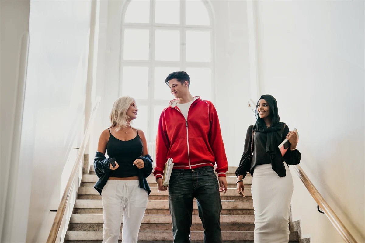 Tre elever går ner för en trappar.