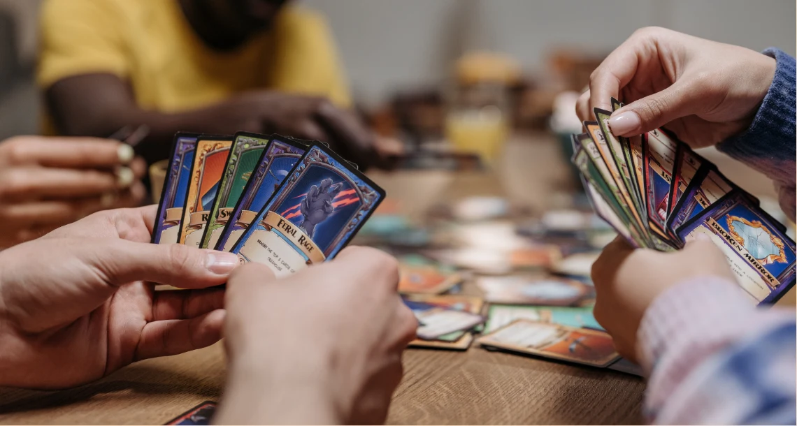 Händer som håller i Pokemonspelkort