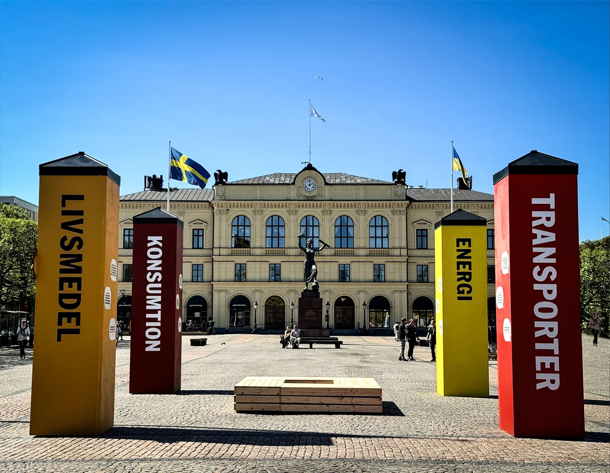 Fyra stora pelare i olika färger står på ett torg