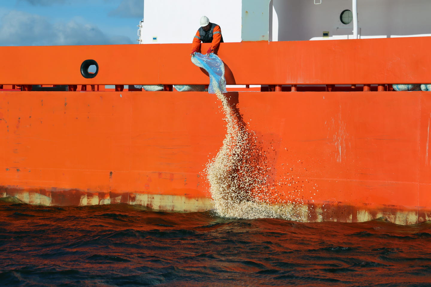 Person slänger popcorn i vattnet från övningsbåt