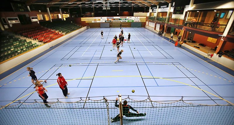 En inomhushall där människor spelar handboll