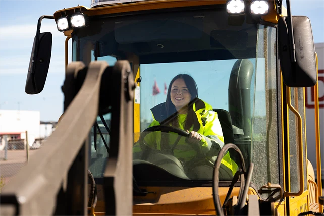 Gymnasieelev kör en hjullastare.