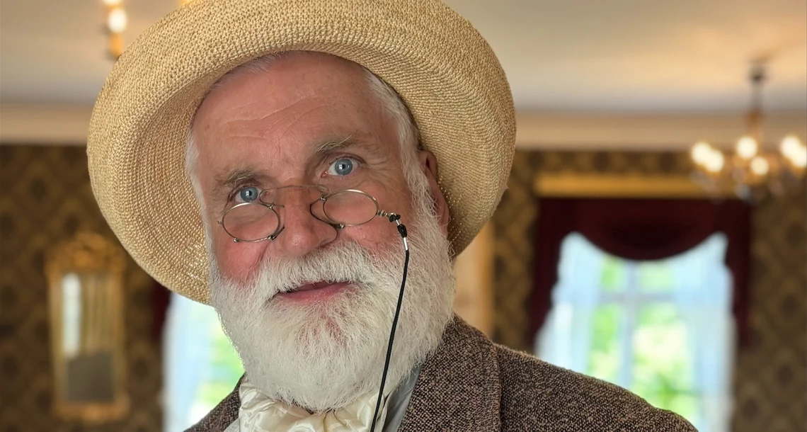 Närbild på skådespelare utklädd till Gustaf Fröding i stråhatt och pincené.