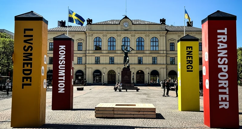 Fyra stora pelare i olika färger står på ett torg