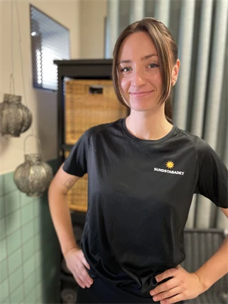 En kvinnlig massör tittar mot kameran