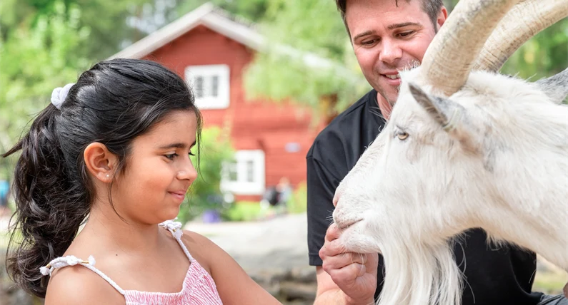 Flicka möter get tillsammans med djurvårdare. 