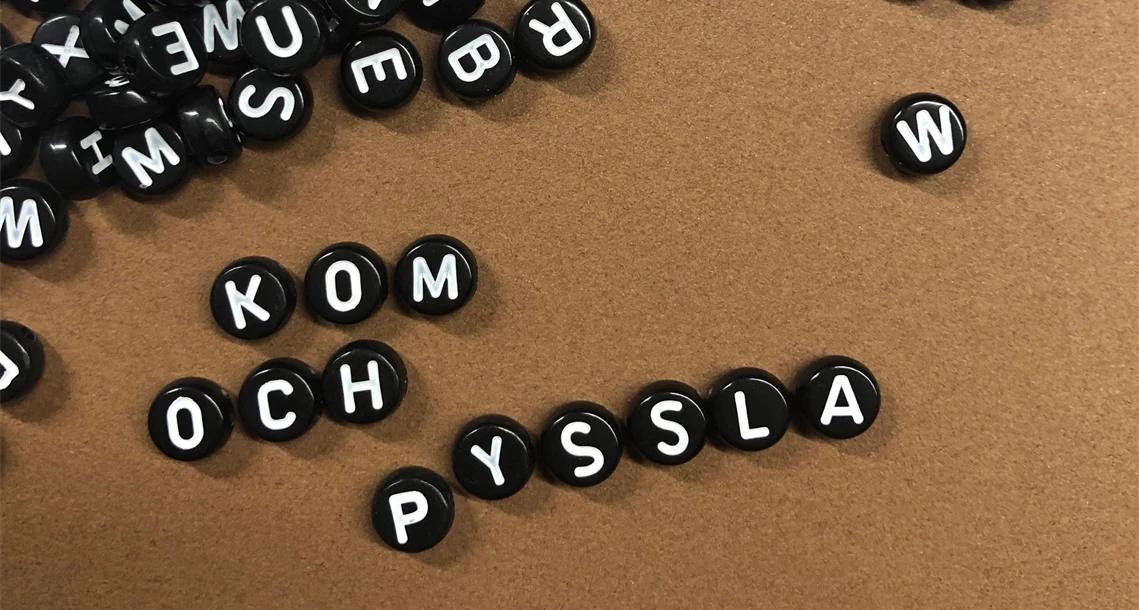 Bokstavspärlor som stavar ut "Kom och pyssla"