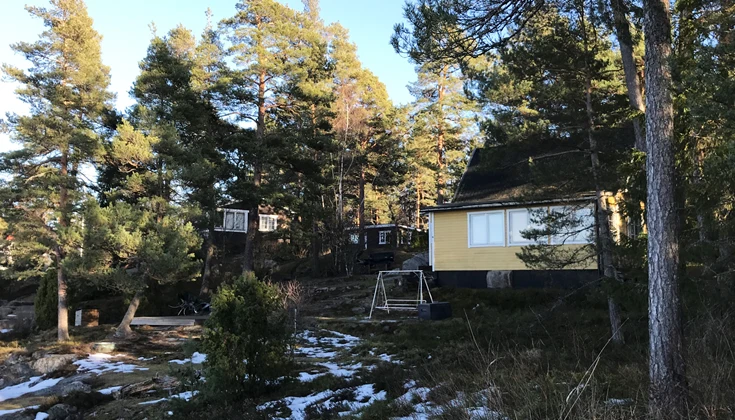 En gul stuga omgiven av natur