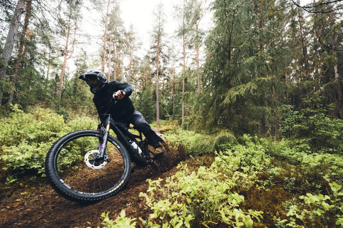 Elev kör mountainbike i en skog