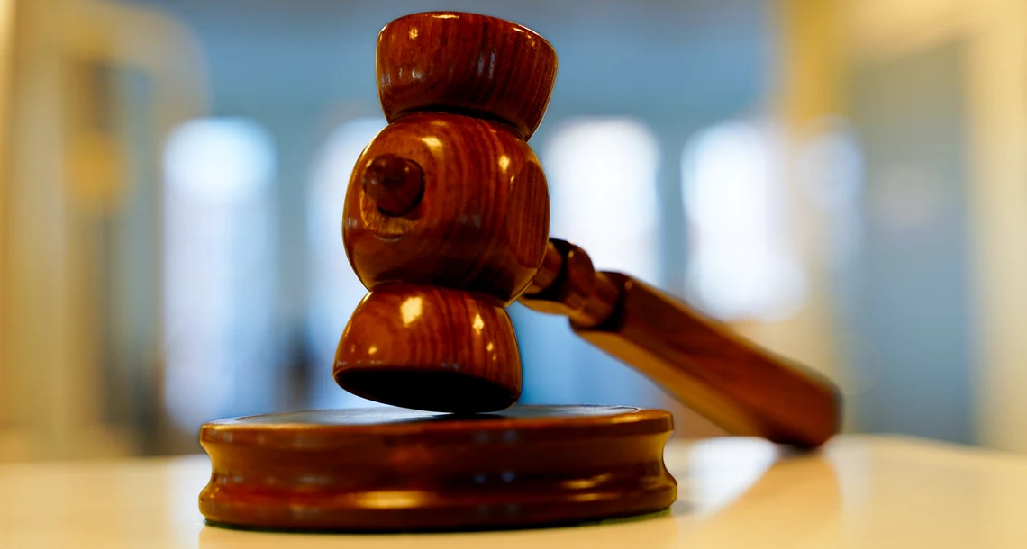 En ordförandeklubba i trä ligger på ett bord.