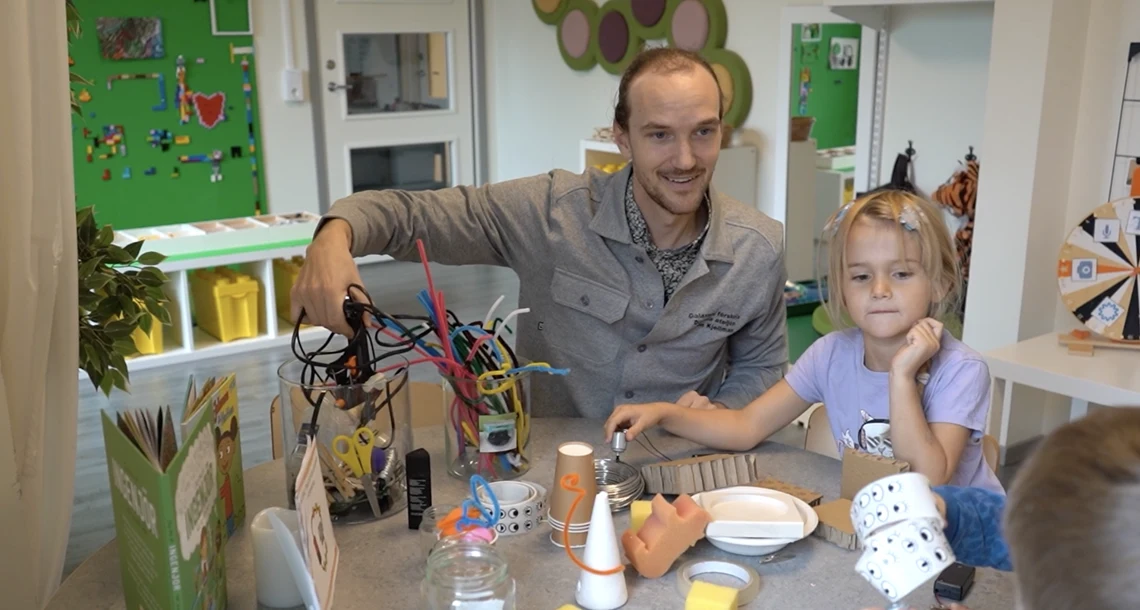 Förskollärare Anton tillsammans med barn i förskolan Galaxens digitala ateljé, där de utforskar och skapar med återbruksmaterial och teknik.