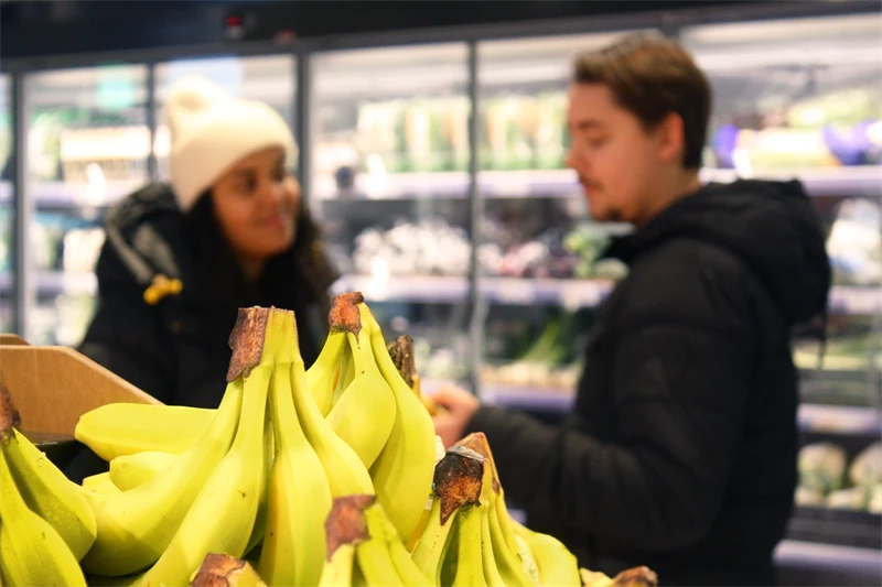 Två personer i en mataffär med bananer i förgrunden
