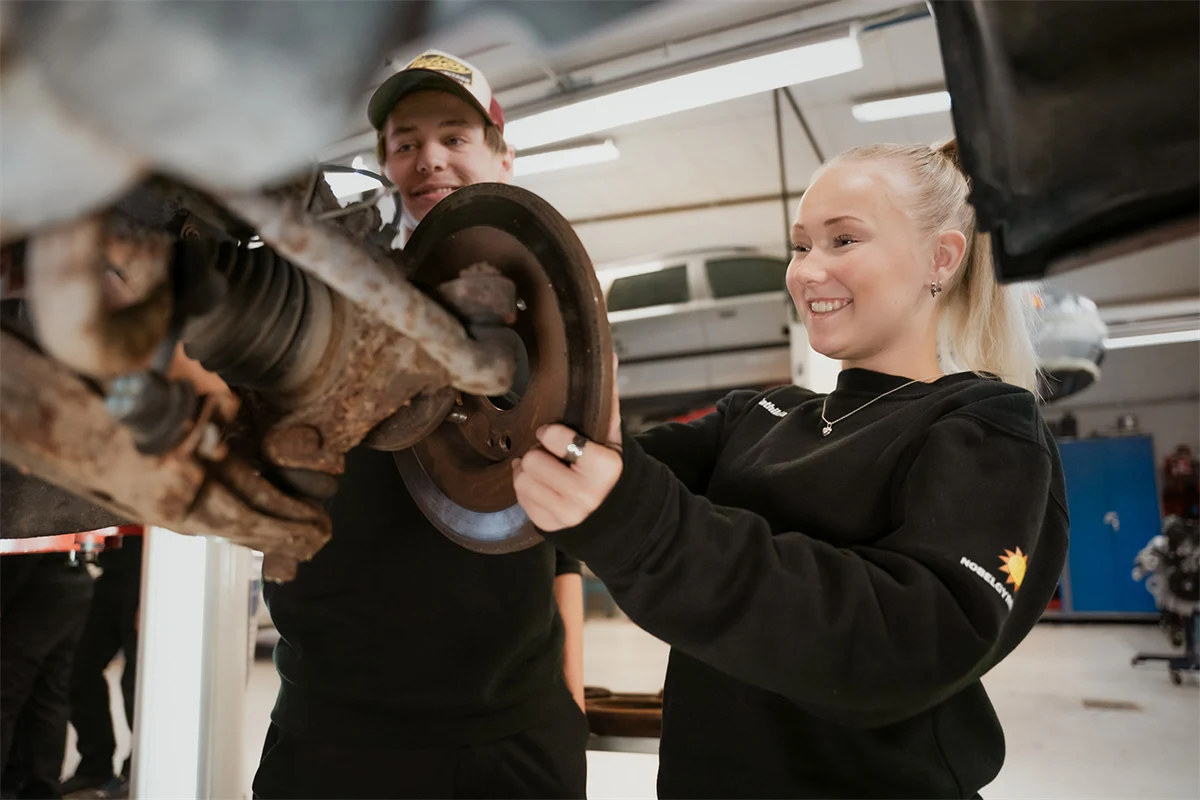 Två elever mekar med en bil.