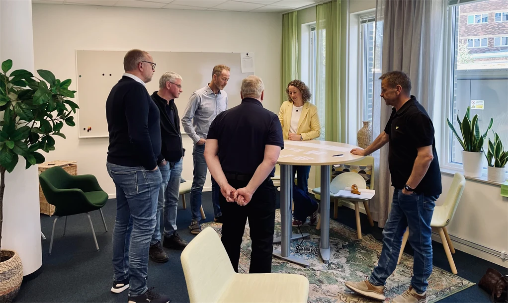 Personer står runt ett bord