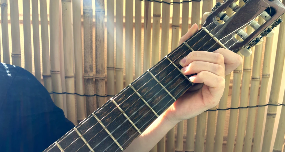 En hand som spelar gitarr
