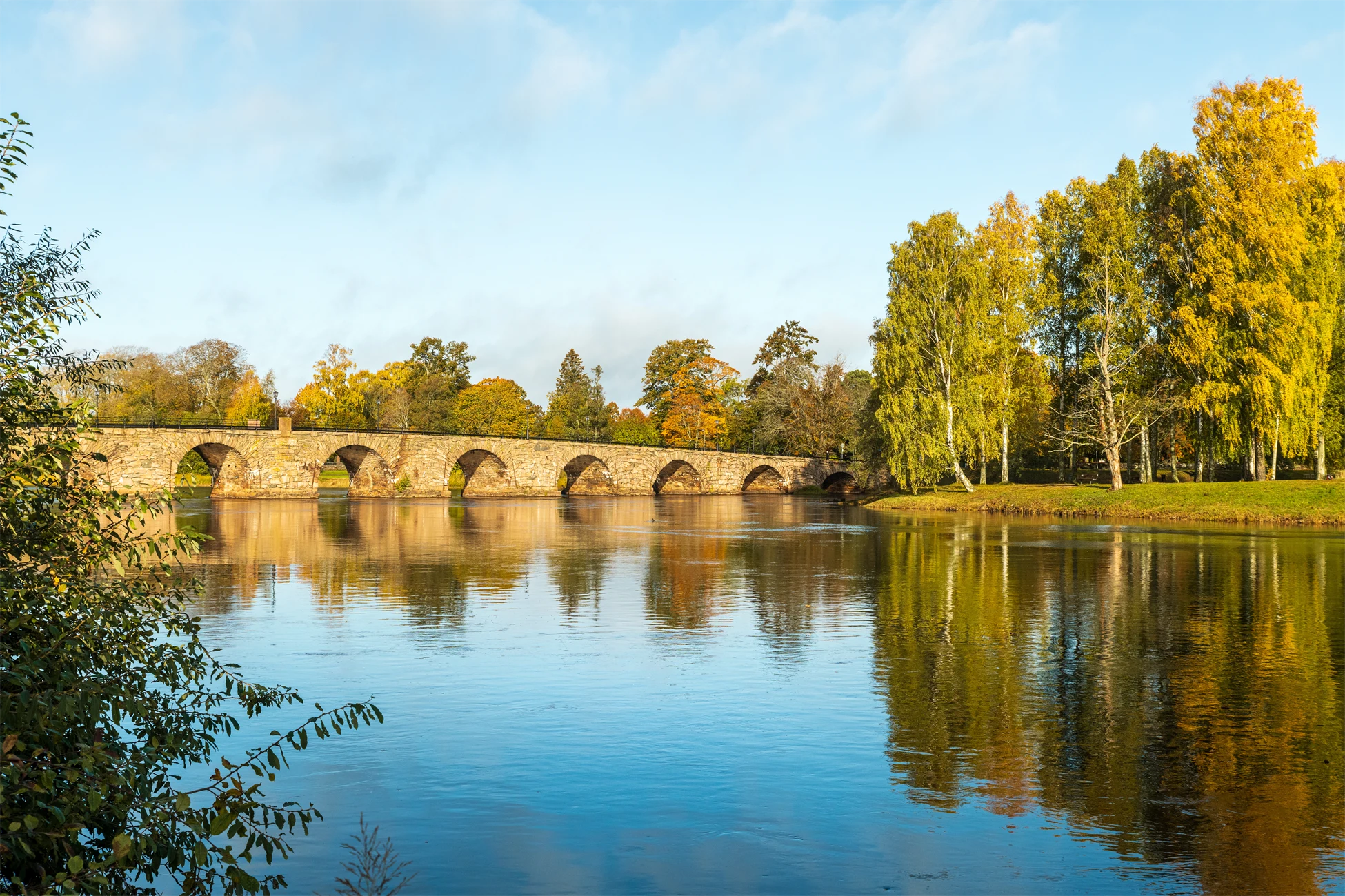 En stenbro över glittrande vatten