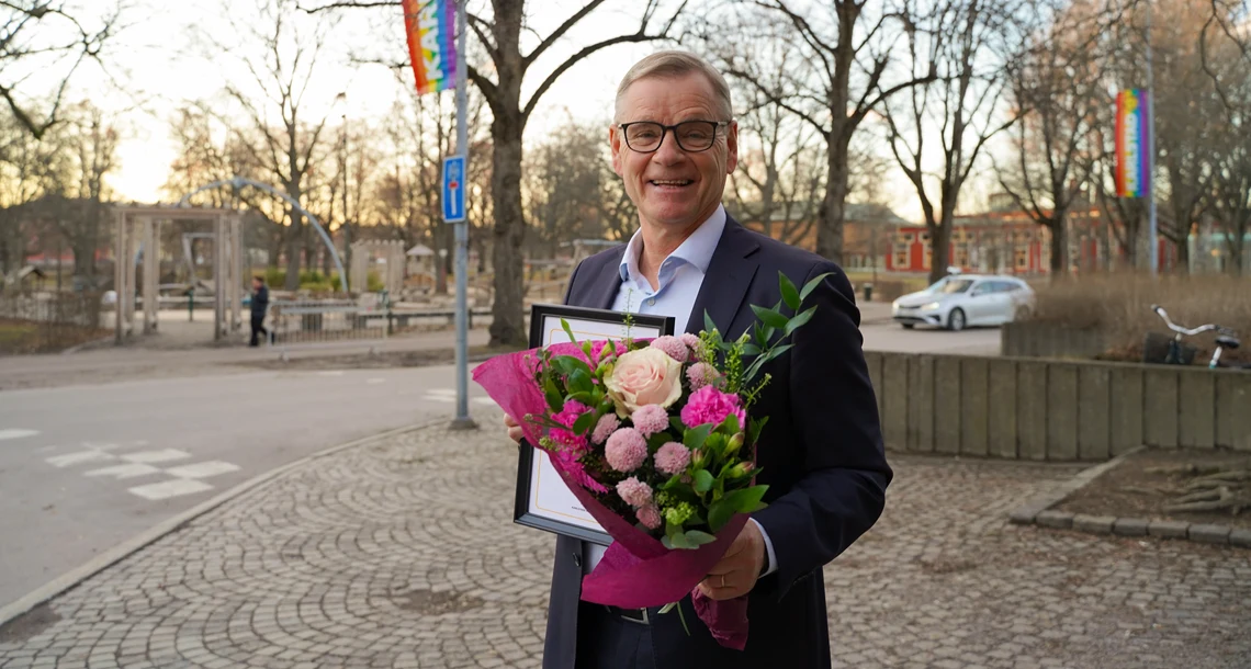 Håkan Loob med blomster, diplom och förtjänstmedalj utanför Bibliotekshuset.