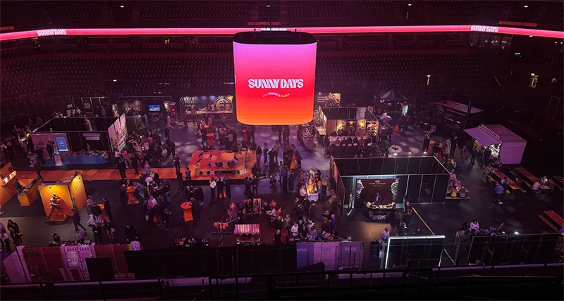 En stor utställningshall med människor som tittar och minglar bland olika montrar