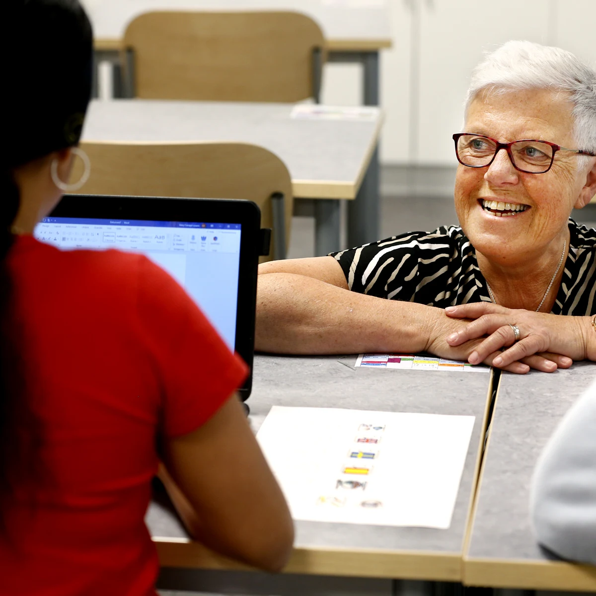 Lärare och elev som skriver på en dator